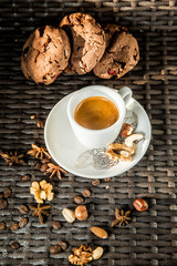 A cup of espresso on a saucer on a background with a cookie