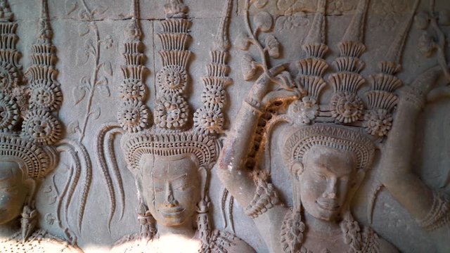 Closeup motion of apsara dancers heads and ornate headdresses.