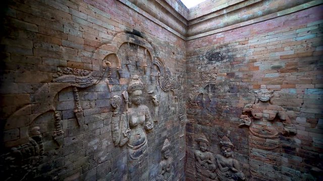 Boom up showing the full length of the interior walls of Prasat Kravan&rsquo;s northernmost tower feature a pair of bas-reliefs of Lakshmi, Vishnu's consort, flanked by devotees