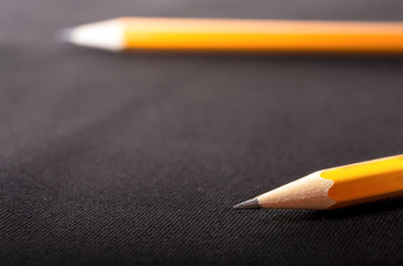 Two yellow Pencils on dark black blurred background. stationery. Office tool. Business concept. Back to school. Draw. Space for text. 