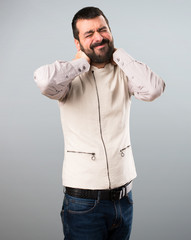 Handsome man with vest with neck pain on grey background