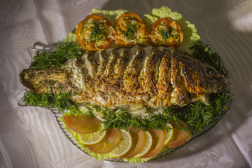Stuffed carp, decorated with vegetables. Fish dish.