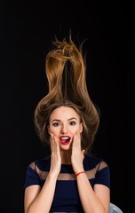 Young surprised woman isolated on black background