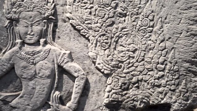 Closeup of apsara dancer sculpture done in bas relief.