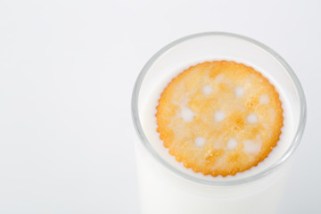 Glass of milk with one cookie