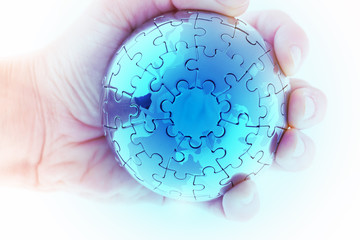 business concept with a hand building puzzle globe on white