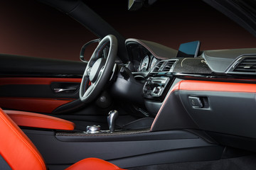 Plakat Modern luxury car Interior - steering wheel, shift lever and dashboard. Car interior luxury inside. Steering wheel, dashboard, speedometer, display. Red and black leather cockpit