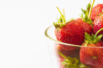 Close-up view of strawberries in a bowl on white background