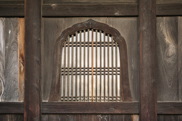 Background featuring details of Japanese traditional wooden windows with parallel and perpendicular elements in design in Kyoto, Japan. 