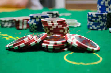 Naklejka premium poker chips with playing cards on a green table