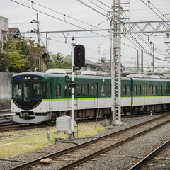 Green train enters local station in Kyoto, Japan