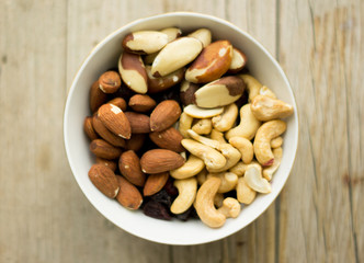 Bowl of mixed nuts on the wooden background, wooden table