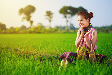 happy farmer woman sitting in rice filed, Thailand