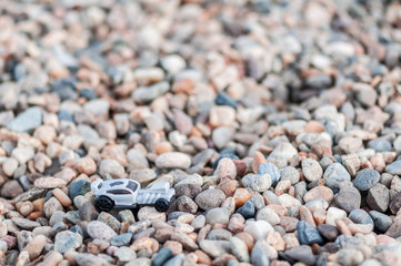 Toy car on gravel. Shallow depth of field.