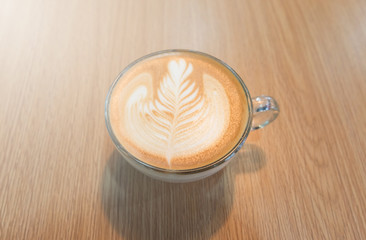 Coffee late art in cup on woden table