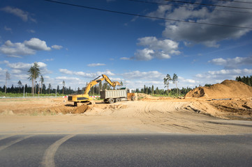 large piles of bright yellow sand fines in the construction of a new road
