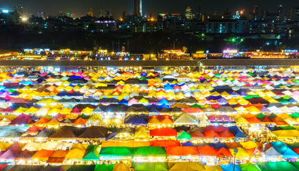 panorama landscape view colorful of plastic roof of tent at ratchada train night market with dark sky of bangkok city. popular place for shopping at night.