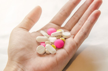 Close-up of the pills on the hand and white background, A hand hold the pills and drug, Pile of the drug and pills on the hand.