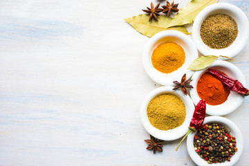 Different spices on white wooden table
