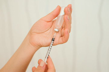 A girl fills a syringe for insulin injections. Diabetes. The short-acting insulin. Insulin injection at home.