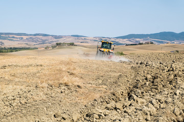 Peasant on the tractor while preparing the field for sowing