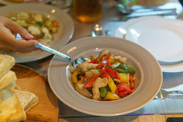 close up of fried chicken and vegetable with oyster oil and hand holding spoon. thai traditional food.