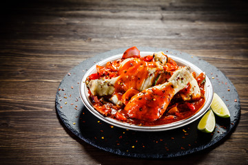 Boiled chicken drumsticks with tomato sauce