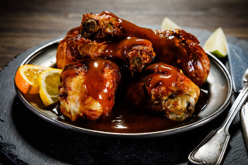 Roast chicken drumsticks on wooden background