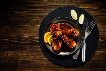 Roast chicken drumsticks on wooden background
