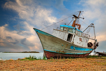 Obraz premium Po Delta Park, Porto Tolle, Italy: old fishing boat on the sea shore