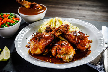 Grilled chicken legs with boiled potatoes on wooden background