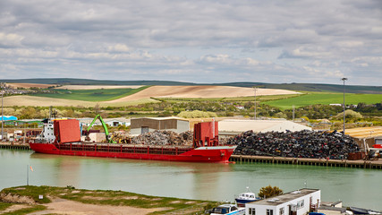 Green crane Loading red cargo Ship With Recycling Steel and extruded car