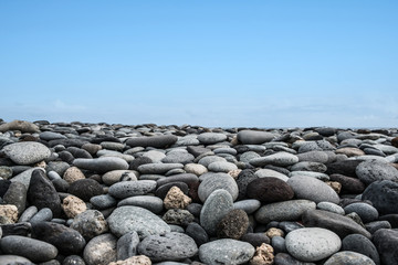 pebble stones, rocks and blue sky horizon