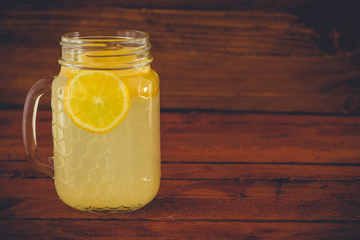 Fresh lemonade in mason jar on wooden background