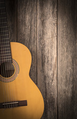 Old classic guitar on a wooden background