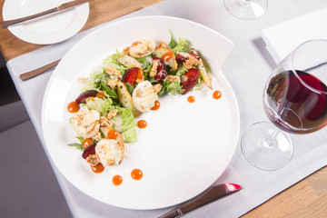 Starter: Mix salads, baked goat cheese, sea-buckthorn jam, caramelized pear with thyme, plum and roast nuts - served in a restaurant