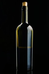 open Bottle of red Wine. Half a Bottle of Wine. A Bottle of Wine on a black background. Bottle with a cork isolated on a black background