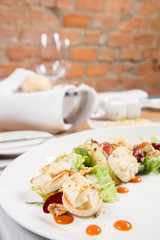 Starter: Mix salads, baked goat cheese, sea-buckthorn jam, caramelized pear with thyme, plum and roast nuts - served in a restaurant