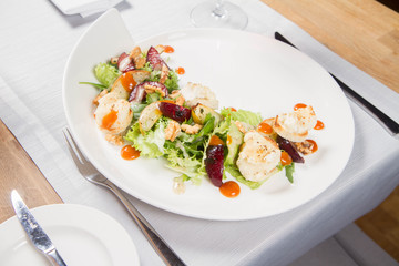 Starter: Mix salads, baked goat cheese, sea-buckthorn jam, caramelized pear with thyme, plum and roast nuts - served in a restaurant