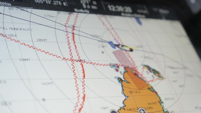 Boat moving on the dashboard GPS navigator. Tracking the route of sea travel on electronic map by coordinates of area, Norway. Movement of boat is displayed on screen of monitor in the present moment