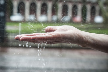 détail main de femme sous la pluie