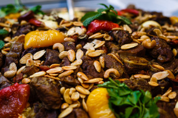 Traditional oriental pilaf on a round platter in the hands of the waiter
