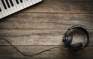 Keyboards and headphones on a wooden background