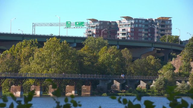 Richmond VA City Meets Nature Over Recreational James River Area with People Jogging and Walking Over Pedestrian Bridges on a Sunny Day in the Commonwealth of Virginia