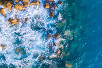 Aerial view on turquoise waves that beat against stones in Montenegro