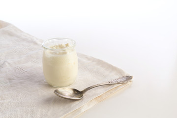Yogurt in glass jar with spoon