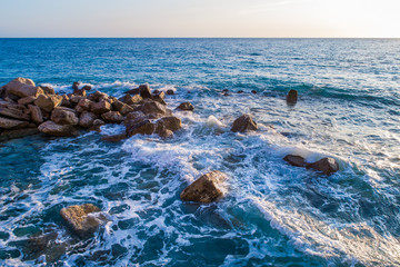 Aerial view on turquoise waves that beat against stones in Montenegro