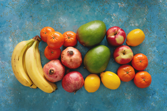Variety of fresh fruits on rustic blue background.
