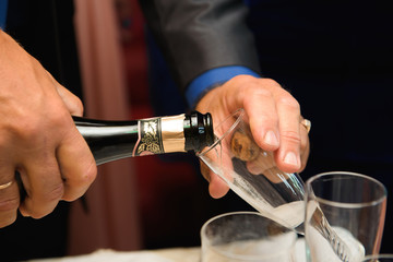 Waiter pours champagne in glasses