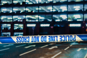 Police tape cordons off a multistorey car park at night upside down